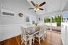 Dining space featuring wainscoting, a ceiling fan, light wood-style floors, lofted ceiling, and a decorative wall