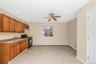 Kitchen featuring brown cabinetry, black range with gas stovetop, a ceiling fan, recessed lighting, and light tile patterned flooring