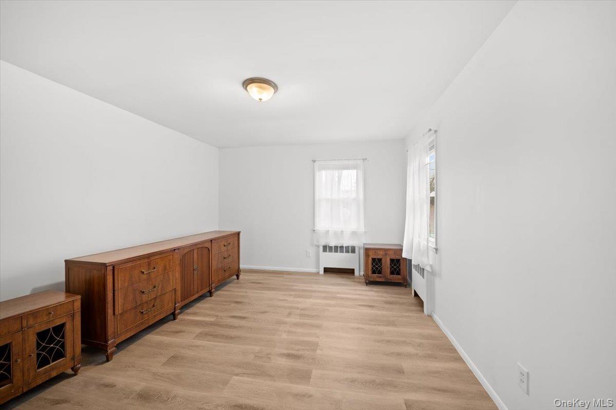 Spacious primary bedroom with corner windows and half bath ensuite, new luxury vinyl flooring and freshly painted.