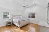 Bedroom with lofted ceiling, light wood-style floors, a ceiling fan, multiple windows, and recessed lighting