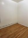 Unfurnished room featuring a baseboard radiator and hardwood / wood-style floors