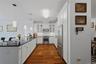 Stainless steel appliances, elegant pendant lighting, and an expansive counter create a stylish and functional kitchen.