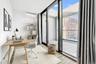Office area featuring plenty of natural light, floor to ceiling windows, an AC wall unit, and light wood-style floors