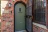 Front door from outside against brick facade