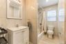 Full bathroom featuring tile walls, vanity, shower / tub combo, and light wood finished floors