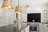 Thermador gas range with custom range hood.