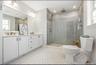 Huge primary bathroom with double vanity and walk in shower .