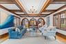 Stunning living room showcasing timeless architectural detail with a coffered ceiling, rich wood trim, elegant chandelier, and beautiful arched doorwa