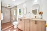 Full bathroom featuring double vanity, a tile shower, and light tile patterned floors