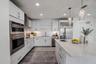 This sophisticated, all-white kitchen exudes modern elegance with its clean lines and luxury finishes.