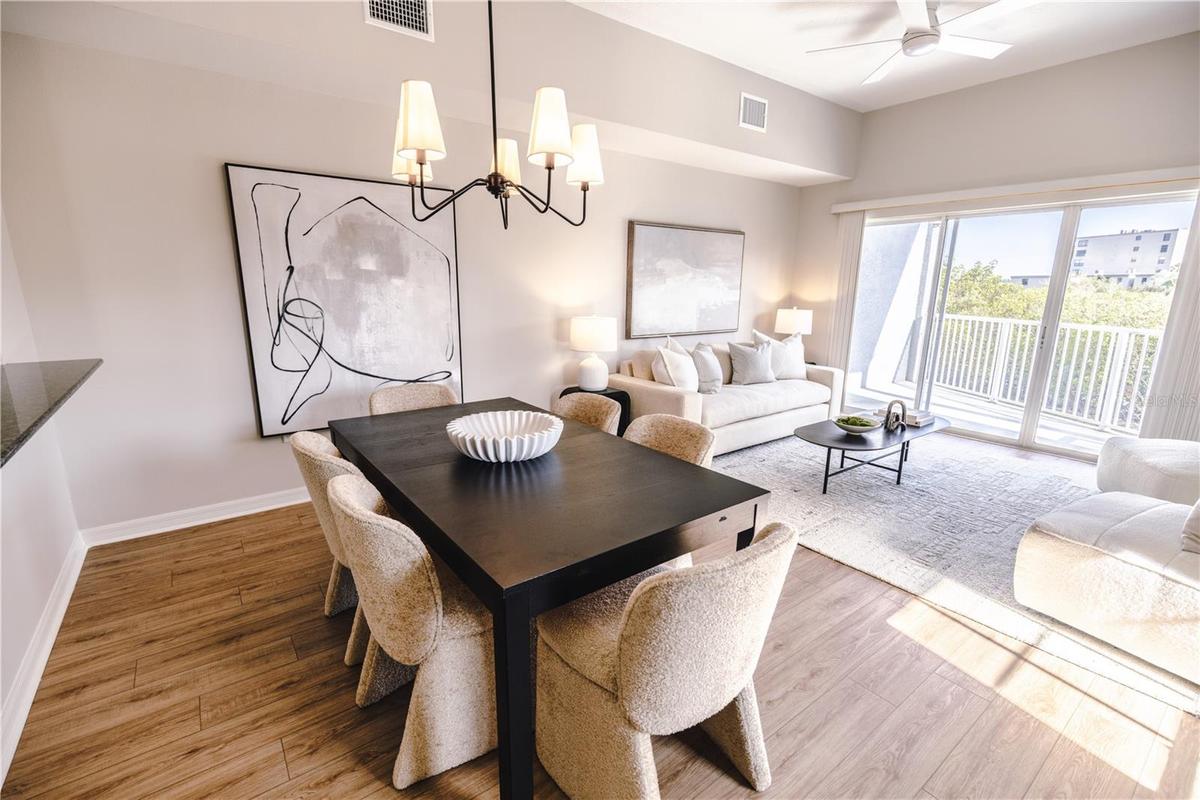 Open concept living and dining room with natural light and balcony overlooking mangroves.