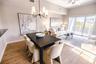 Open concept living and dining room with natural light and balcony overlooking mangroves.