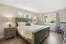 Bedroom featuring multiple windows and dark wood finished floors