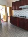 Kitchen with reddish brown cabinets, under cabinet range hood, tasteful backsplash, wood finish floors, and gas cooktop