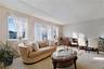 Bright living area featuring multiple large windows, wall-to-wall carpeting, and a textured ceiling