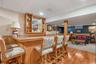 Indoor dry bar featuring a wainscoted wall, a paneled ceiling, light wood-type flooring, wooden walls, and open shelves