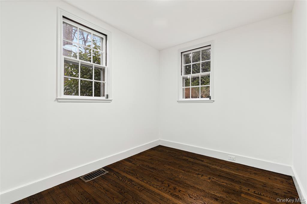 Spare room with baseboards, and dark wood finished floors