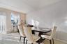 Dining area featuring light-colored carpeting and a window with white sheer curtains