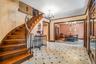 Staircase with a chandelier, crown molding, radiator heating unit, and tile patterned floors