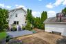 Rear exterior featuring a multi-level deck with white railings, a concrete patio, and even a basketball hoop!