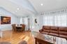 Living room with light wood-type flooring, recessed lighting, and high vaulted ceiling