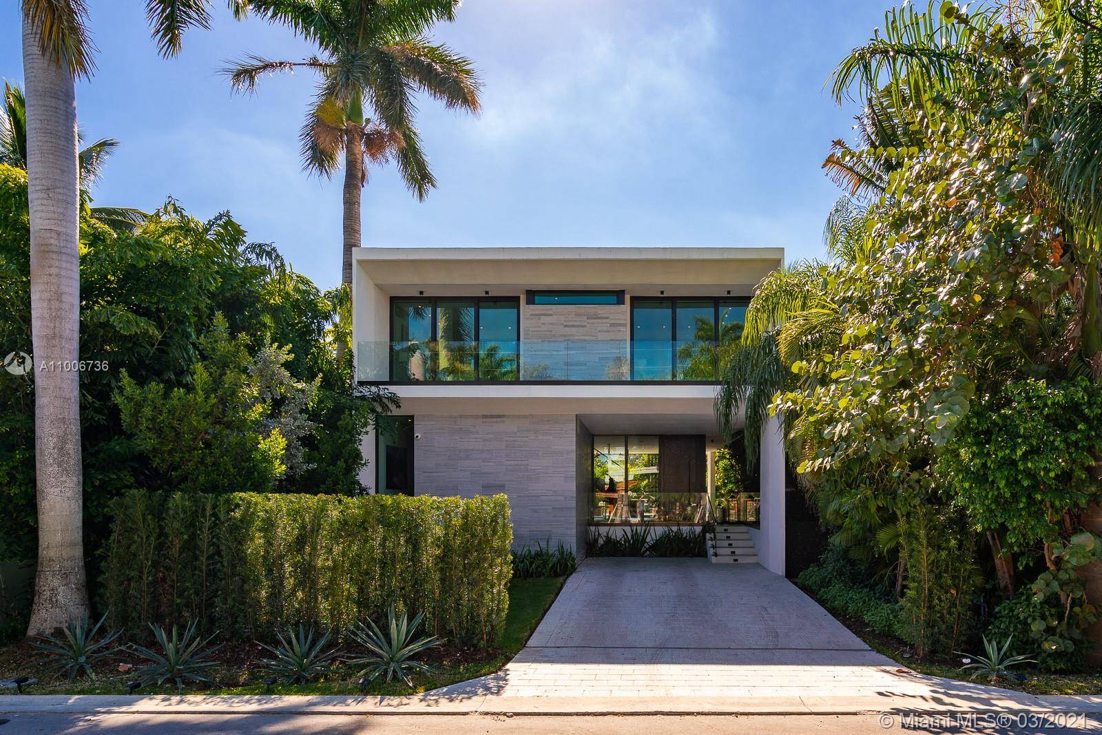 Contemporary home on Palm Island, boasting artistic pavers, unique landscape design, with mature trees, wood accents, Louver doors, Veneta Cucina cabinets, custom surround pre wired smart home.