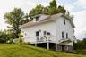 Back of property with a wooden deck, a chimney, and a yard