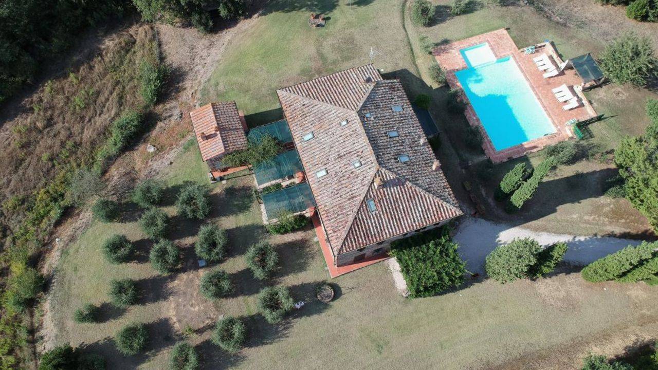 For sale near Siena restored country house composed of six apartments and surrounded by well-tended gardens. Pool, well and small olive grove.