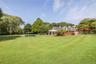 View of green lawn featuring covered porch and an outdoor pool