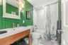 Bathroom with shower / tub combo, vanity, and light tile patterned floors