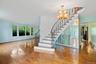 Staircase featuring hardwood / wood-style floors, a chandelier, a baseboard radiator, and a baseboard heating unit