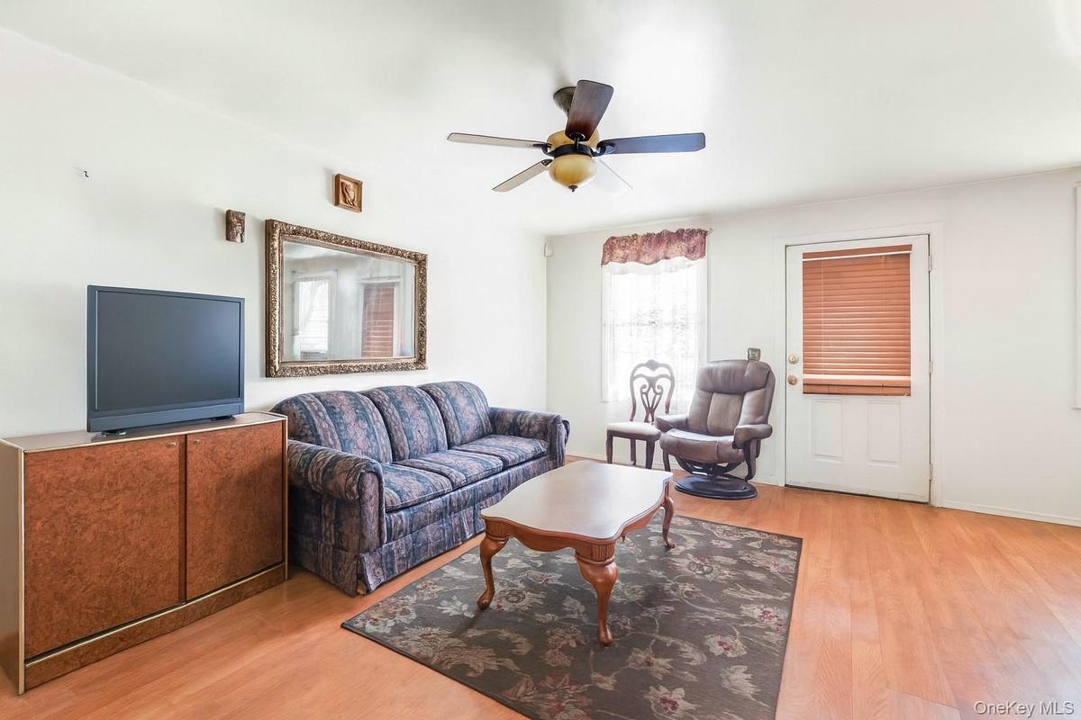 Living area with light wood-type flooring and a ceiling fan