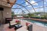 Screened lanai overlooking custom pool, spa, and pond views.