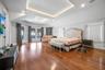 Bedroom featuring french doors, wood finished floors, vaulted ceiling, access to exterior, and a raised ceiling
