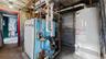 Utility room with gas water heater and a heating unit