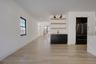 right dining space positioned beside kitchen and living room featuring wet bar and large glass sliders, offering great natural light and easy access t