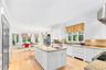Kitchen with white cabinets, light wood-style floors, and light stone counters
