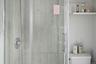Full bath featuring a shower stall and toilet