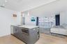 Kitchen with open floor plan, light wood-type flooring, hanging light fixtures, appliances with stainless steel finishes, and gray cabinetry