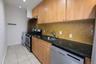 Kitchen with dark stone counters, appliances with stainless steel finishes, backsplash, light tile patterned floors, and under cabinet range hood