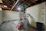 Unfinished basement with a heating unit and electric water heater