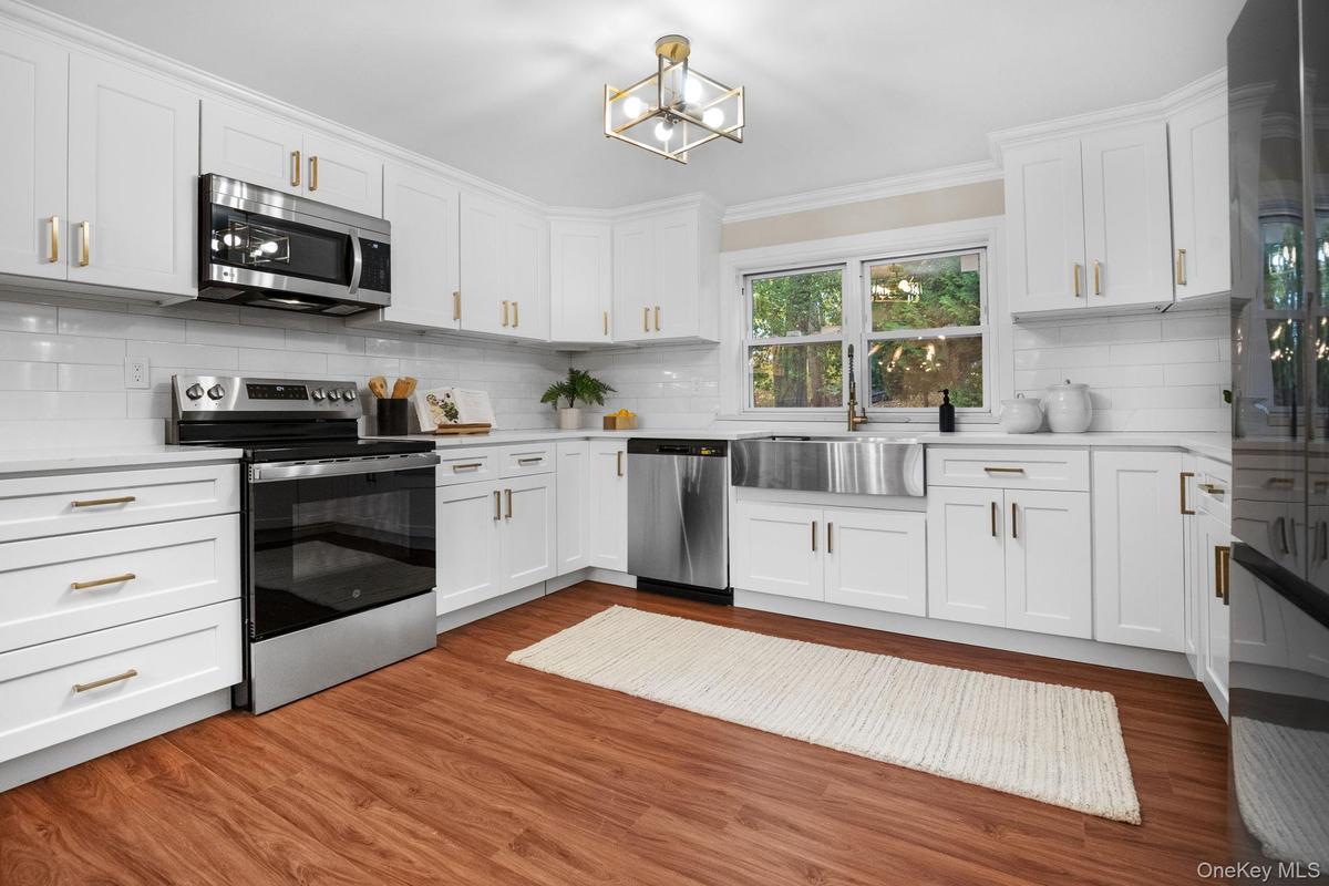 Sleek quartz counters and stainless steel appliances highlight the fresh, modern design of this fully renovated kitchen.