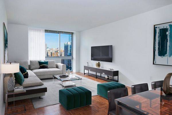 Great 2 bedroom apartment with over sized windows showcasing open views across Chrystie street, an open kitchen with eating bar, wood floors and an in unit washer dryer.