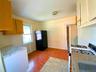 Kitchen featuring gas range gas stove, freestanding refrigerator, light tile patterned flooring, tasteful backsplash, and light stone counters