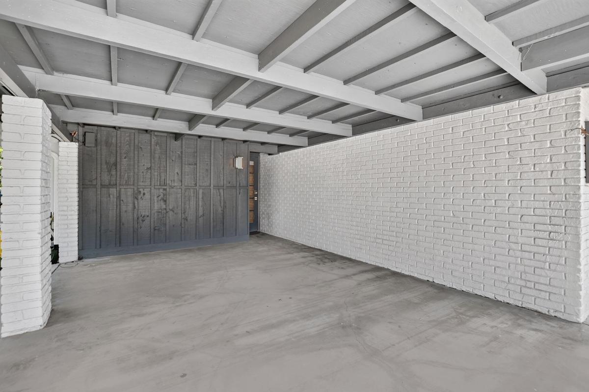 This oversized carport has plenty of room for a typical SUV with room to walk around the vehicle. It has lighting and an entrance door to the house. P