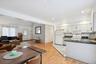 Kitchen with light wood-type flooring, tasteful backsplash, white appliances, sink, and white cabinets
