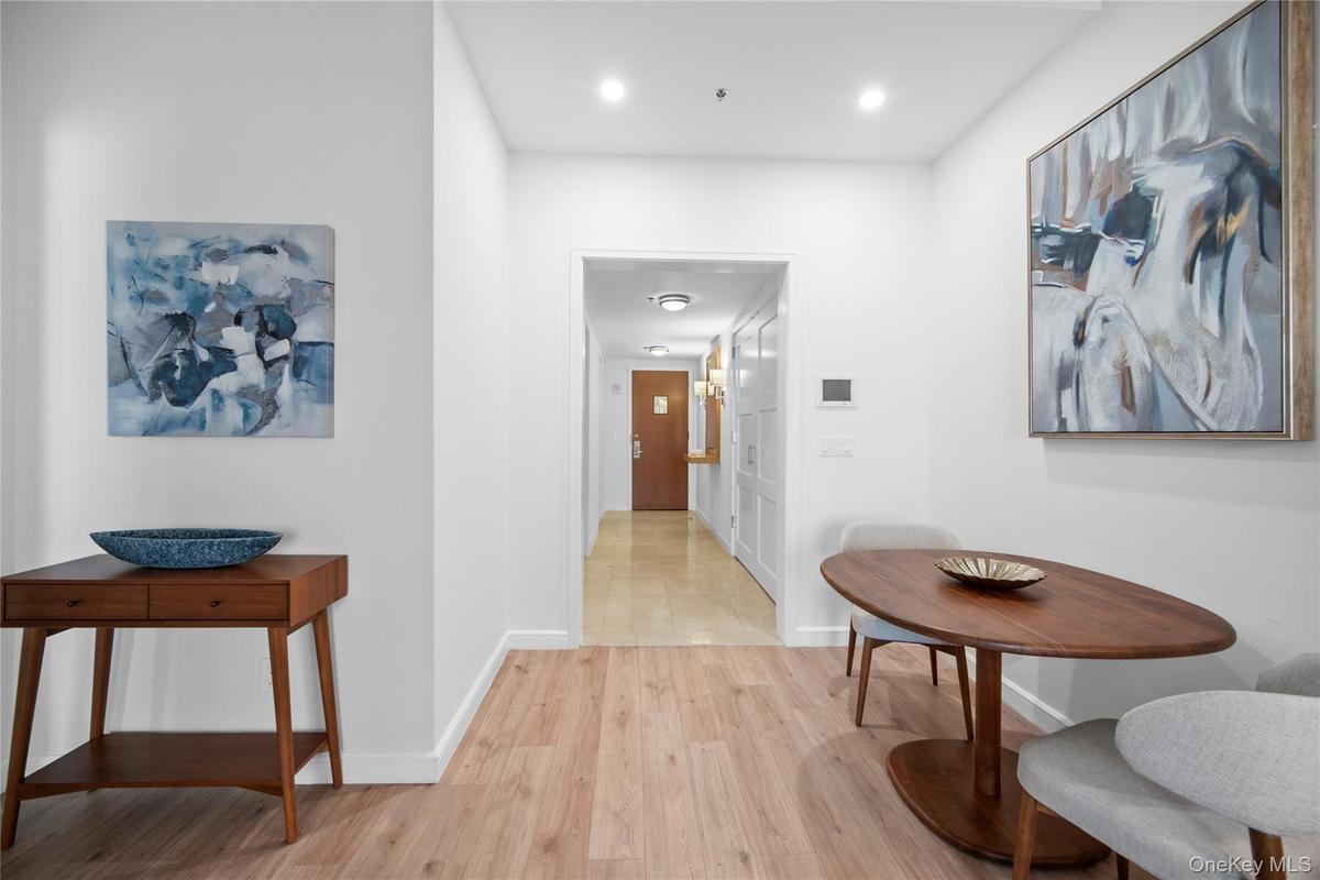 Hall featuring light wood finished floors, baseboards, and recessed lighting