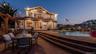 Back of house featuring a patio area, an in-ground hot tub, and outdoor dining area