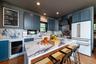 Kitchen with a breakfast bar area, white appliances, decorative backsplash, wine cooler, and a center island