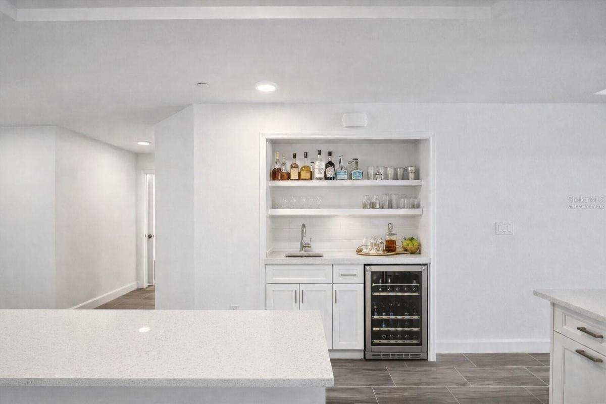 Virtually staged wet bar in place of pantry, water available on this wall